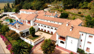 Vista aérea de hotel en boyaca, con vista al bosque, piscina e ingreso