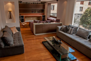Sala en piso de madera con chimenea en colores cálidos