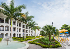 Hotel de tierra caliente con hilera de palmeras