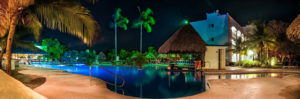 vista panorámica de piscina en la noche con iluminación del hotel y cielo estrellado