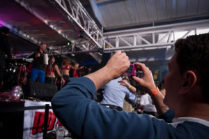Publico grabando con su cámara a show de salsa muy feliz