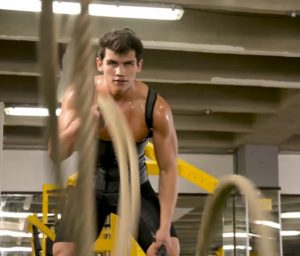 Hombre haciendo ejercicio en gimnasio mientras utiliza faja en látex tipo chaleco