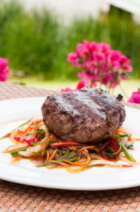 Ensalada salteada con porción de carne asada en restaurante campestre