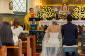 Padre dando sermón a futuros esposos en iglesia.