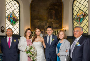 Foto familiar con los padres dentro de iglesia después de que los novios se casaron.