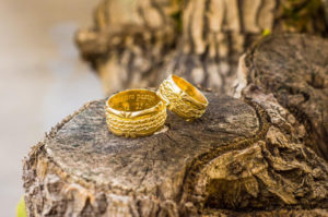 Anillos de boda con palabra de amor para la pareja, encima de un trozo de madera.