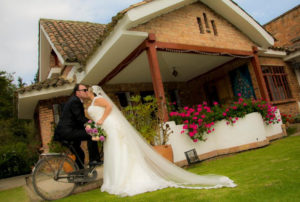 Pareja de recien casados besándose en casa campestre.