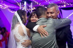 Los padres de la novia, abrazan a los recién casados en la fiesta de celebración llenos de alegría.