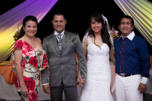 Pareja de amigos posando junto a los recién casados en su día de celebración.