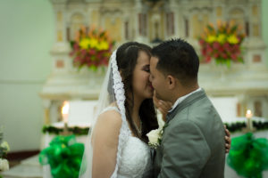 Pareja de nocios casándose en la iglesia, dando el si.