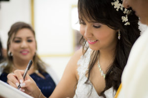 Mujer irmando su partida de matrimonio en la iglesia