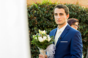 Hombre en el día de su boda con el ramo de rosas en las manos para su amada, esperándola