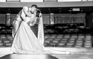 Pareja de recién casados besandose abrazados en el interior de un teatro, fotografía a blanco y negro