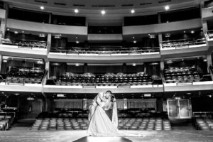 Pareja besandose con fondo el teatro, fotografía blanco y negro